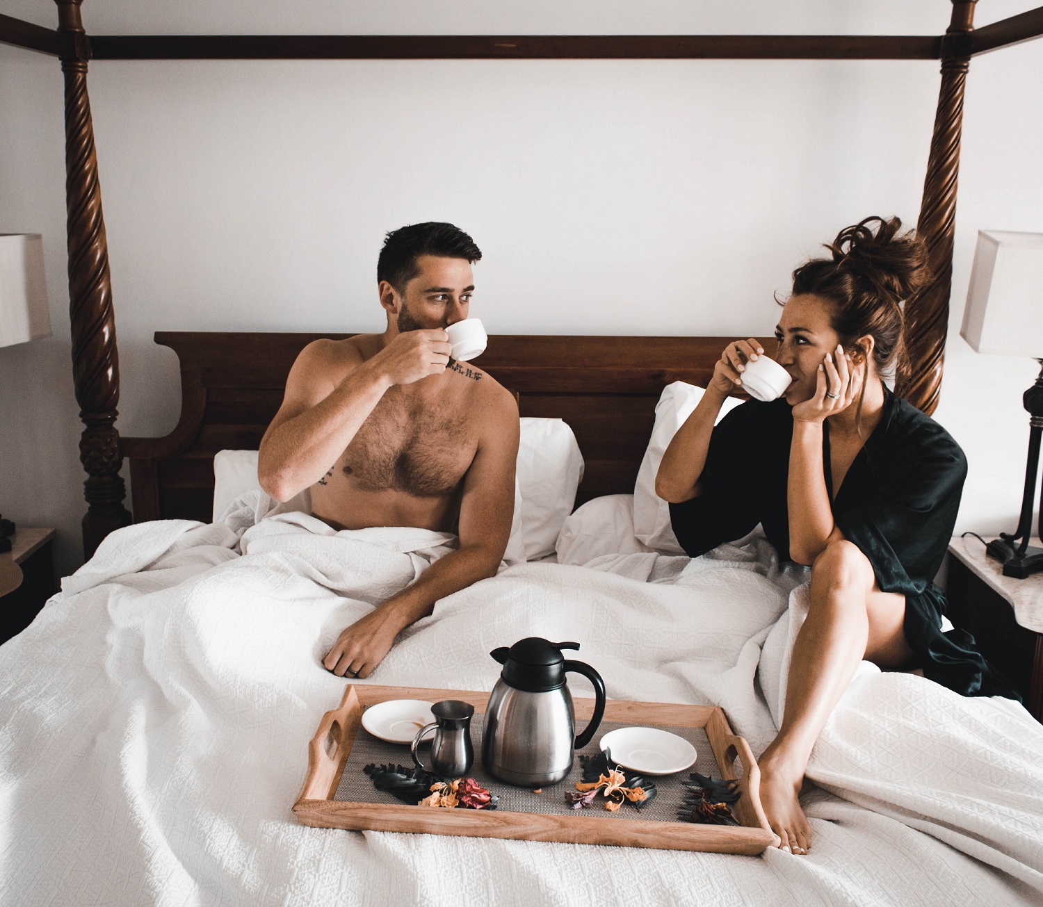 A man and woman in bed, eating oysters