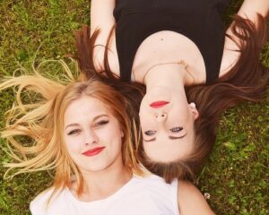 2 young women lie on the grass