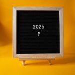 A blackboard has the letters 2025 and a question mark on it