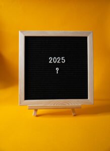 A blackboard has the letters 2025 and a question mark on it